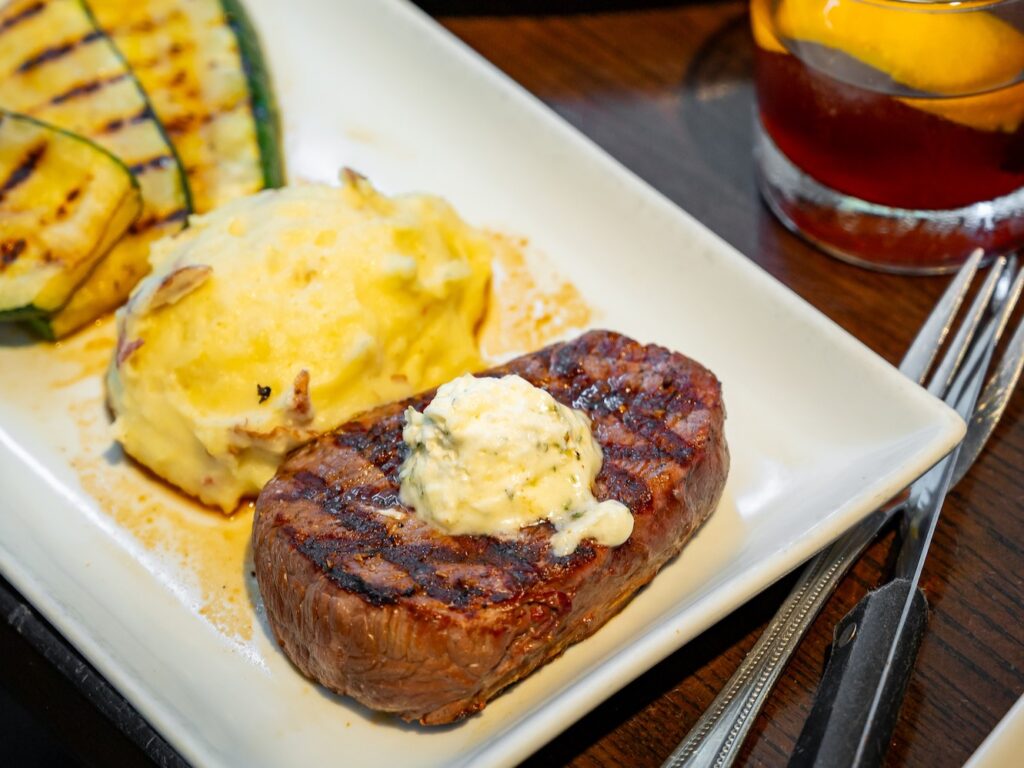 Lunch of steak and mashed potatoes on plate at Embers Wood Fired Restaurants.